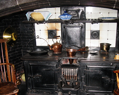vintage kitchen image with cast iron range and copper pans